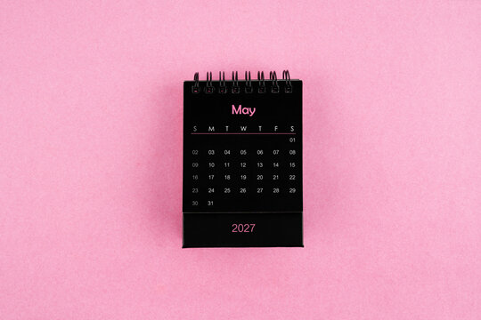 Black calendar for May 2027 year on pink color background.