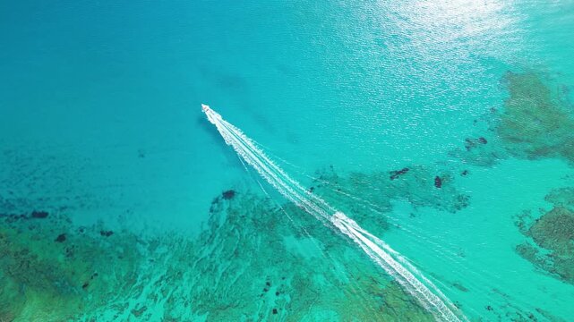 Top down aerial view of two speedboats driving fast and leaving long white wakes on a turquoise transparent sea surface in Balos lagoon, beautiful Crete island, Greece. High quality 4k footage
