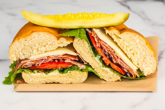 Italian deli sandwich with cheese vegetables and pickle spear