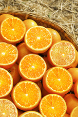 Fototapeta premium Fresh Cut Oranges in Basket - Tasty Citrus Fruits from Orchard