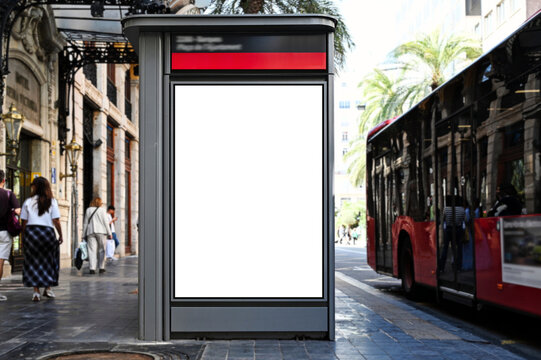 lightbox with vertical blank ad panel. billboard display. empty white advertising sign. mockup base. city transit station. urban street. green park and street setting with palm trees. outdoor advert