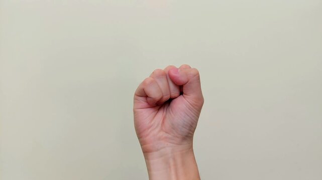 A hand repeatedly clenching and opening the fist, showing the palm against neutral background with copy space, for body motion, stress relief, muscle tension, flexibility, physical exercise concepts.