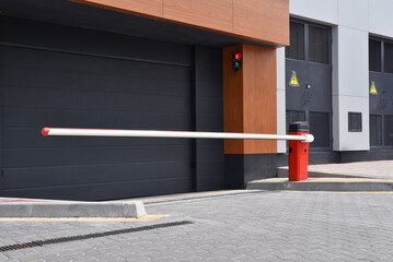 Automatic sectional garage gate with red boom barrier © Sergey