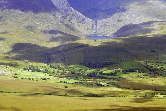 Wide valley in a mountain landscape with different shades of green and shadow, Connor Pass, Ireland