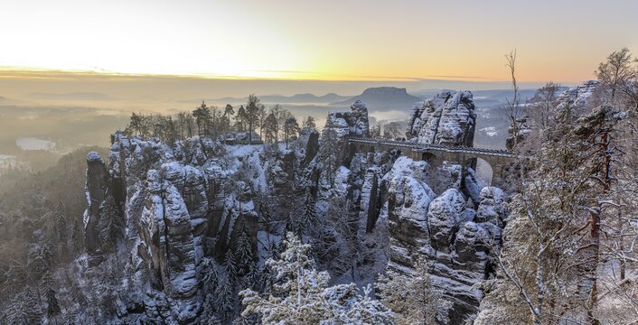 Snow-covered rock castle Neurathen and Bastei bridge in the morning, in the background the Lilienstein, Saxon Switzerland, Saxony, Germany