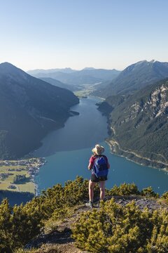Young hiker, woman looking into the distance, view from B&auml;renkopf mountain to Lake Achen, left Seebergspitze and Seekarspitze, right Rofan Mountains, Tyrol, Austria