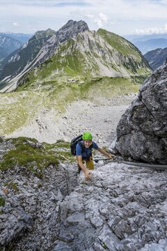 Young man climbing in via ferrata, via ferrata Brudertunnel, hiking trail to Lamsenspitze, Below Kessel with Lamsenjochh&uuml;tte, Karwendel Mountains, Alpenpark Karwendel, Tyrol, Austria