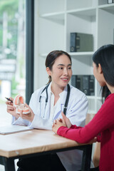 Fototapeta premium Female dentist explaining oral healthcare to patient using teeth model