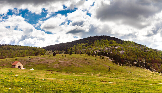 Stone shepherd hut on Brezovac meadow under dramatic clouds, Dinara mountain, Croatia