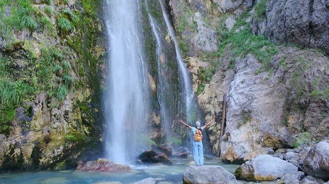 Albania Theth offers breathtaking landscapes with majestic waterfalls and lush greenery. A woman explores scenic spots ideal for adventure and relaxation in this beautiful travel destination.