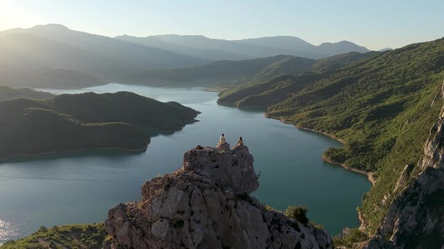 Albania boasts the stunning Bovilla Lake, A couple watching the sunrise. As the sun sets, breathtaking views emerge, creating a serene escape for travelers seeking beauty and adventure.