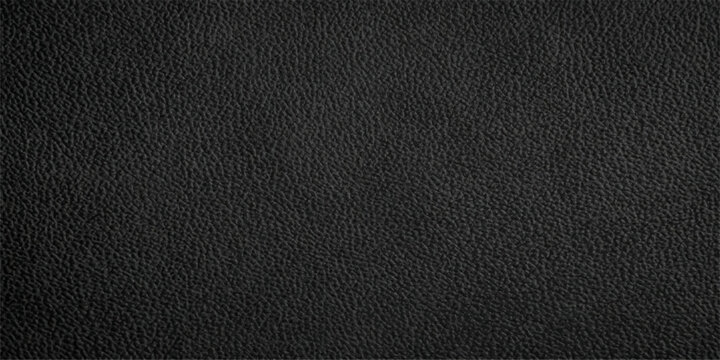 Close-up of a textured black leather surface, showing its grain and subtle variations in light and shadow.