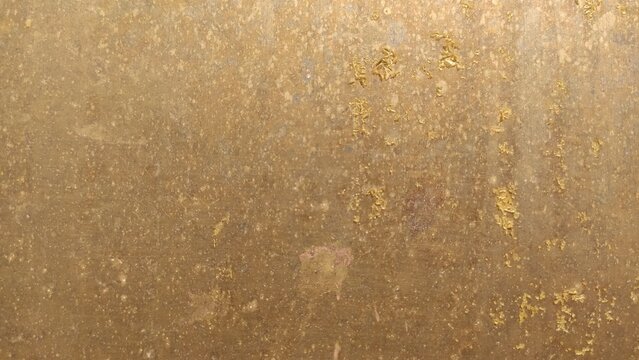 Scratched Golden Metal plate with a heavily distressed and oxidized surface. For steampunk aesthetics, luxury grunge backgrounds, and industrial machinery textures.