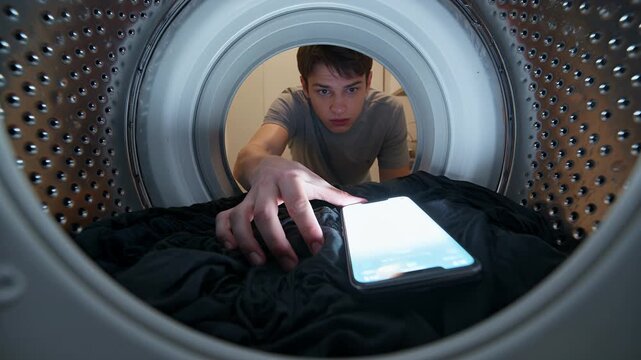 Washing machine, smartphone and man reaching inside for laundry accident with glowing screen. Housework, electronics and forgotten device in domestic appliance for repair, damage and insurance claim