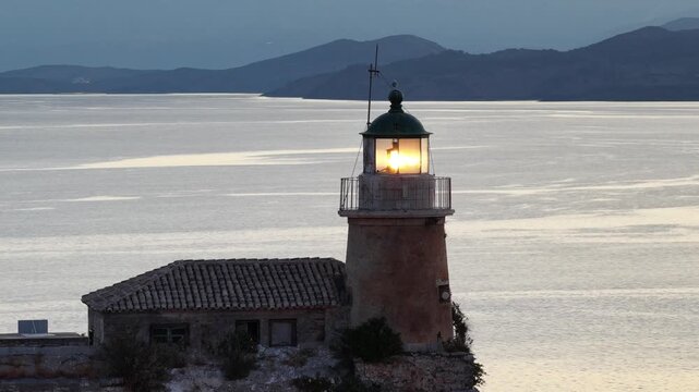 Historic lighthouse flashes at twilight in Corfu Greece