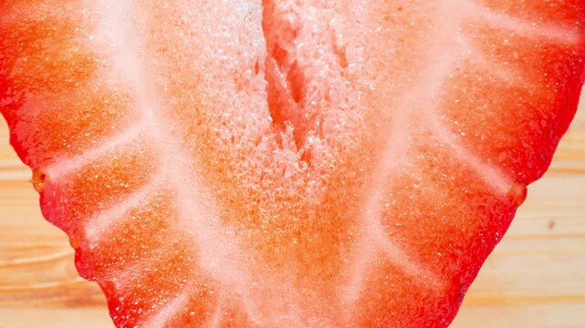Fresh strawberry half captured in high detail displays natural patterns and vivid color gradients, representing food photography, culinary creativity, seasonal harvests, nutritious fruit consumption.
