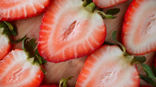 Macro-style view of fresh strawberry halves emphasizes texture and color contrast, making it suitable for dessert recipes, food marketing, fruit branding, and fresh ingredient concepts. 4k.
