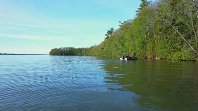 Beautiful lake Couchiching in Orillia Ontario Canada north of Simcoe Lake. Bass season opener. Motor boat with fishermen on water. Aerial view shot. Fishing boat and two anglers enjoying leisure.