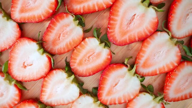 Detailed strawberry cross-sections display natural patterns and moisture-rich flesh, illustrating farm-to-table ingredients, food photography, nutrition awareness, and agricultural abundance. 4k.
