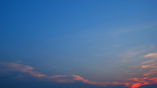 A sunset sky timelapse video featuring thin cirrostratus and altostratus clouds glowing with warm golden light, creating a serene atmosphere that symbolizes tranquility, reflection, nature's beauty.

