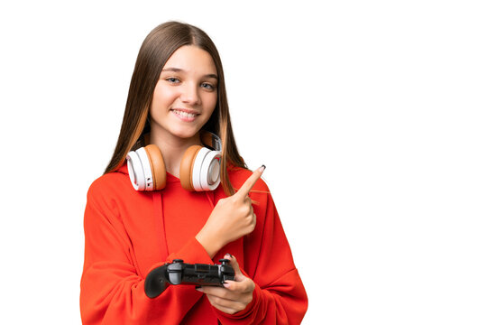 Teenager caucasian girl playing with a video game controller over isolated background pointing to the side to present a product