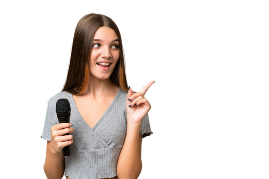 Teenager singer girl picking up a microphone over isolated background intending to realizes the solution while lifting a finger up