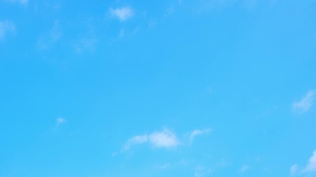 A blue sky timelapse video featuring scattered fair-weather cumulus and small stratocumulus clouds drifting gently overhead, creating a bright, peaceful atmosphere that symbolizes clarity, openness.

