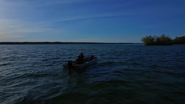 Beautiful lake Couchiching in Orillia Ontario Canada north of Simcoe Lake. Bass season opener. Motor boat with fishermen on water. Aerial view shot. Fishing boat and two anglers enjoying leisure.