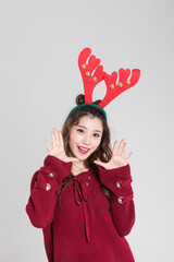 Cheerful young woman wearing Christmas reindeer antlers © HanQuang