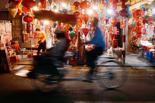 Night market scene with bicycles and lanterns in a busy street