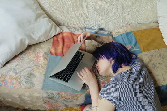 Alternative young adult looking tired at their laptop