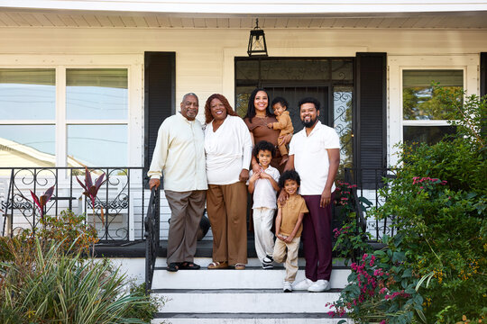 Family Stands Together on Front Steps at Home