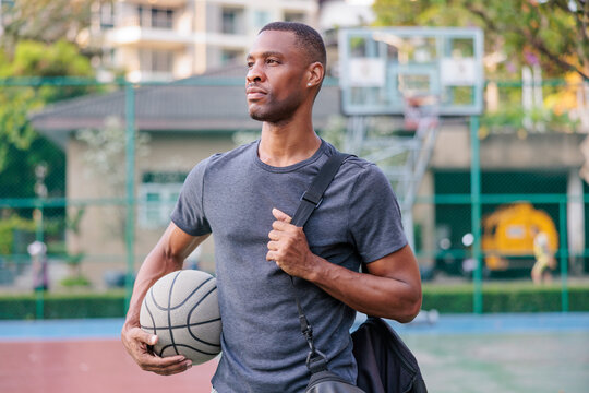 Basketball player with ball and bag looks to the future.