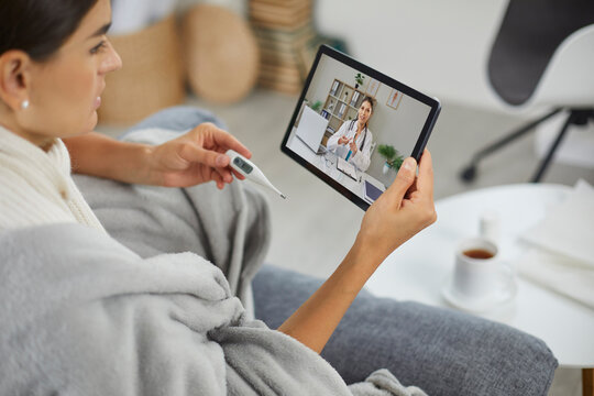 Patient and doctor consultation on tablet via telemedicine. She checks a thermometer, shares her temperature, and gets video chat guidance from home. Modern digital healthcare for home patients.