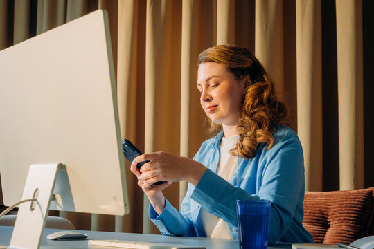 A woman uses a mobile phone in the office
