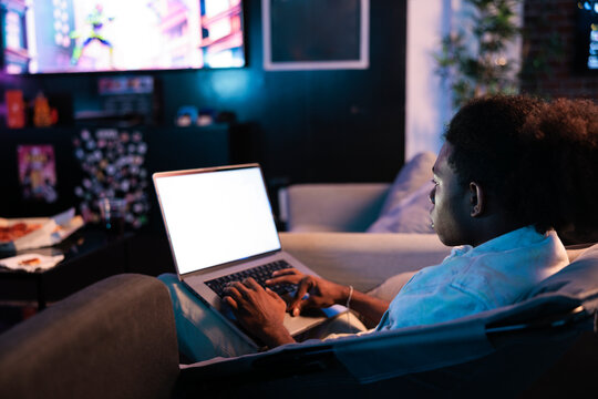 Man using laptop while looking at screen in living room