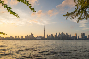 Naklejka premium Skyline view of Toronto with CN-Tower over Lake Ontario from Centre Island at sunset