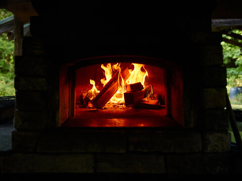 A wood-fired oven preheating in preparation for a dinner service