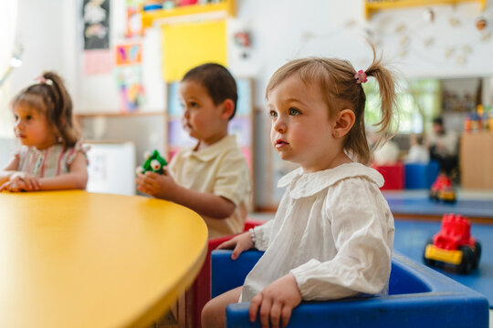 Toddler girl captivated watching in preschool classroom