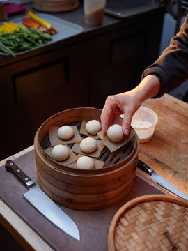 Cooking dumplings in a kitchen using a bamboo steamer