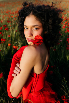 Woman with poppy in vibrant red dress