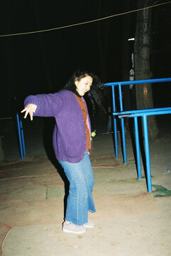 Young Woman Dancing Outdoors at Night on 35mm Film