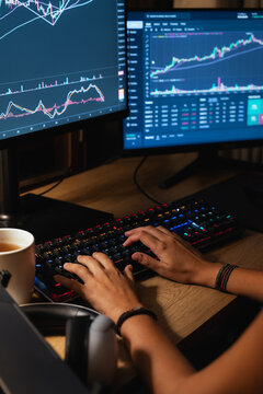 Trader hands working with Stock chart on Multiple Screens
