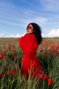 Woman covering eye with poppy