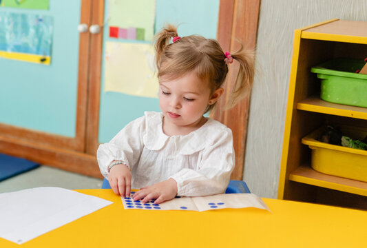 Young girl learning numbers in kindergarten class
