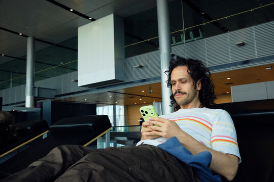 Man using smartphone while waiting at Helsinki Airport
