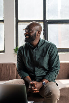 Smiling Professional Entrepreneur With Glasses Sitting on Couch