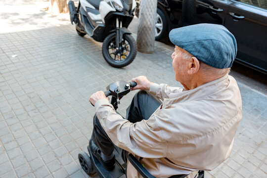 Elderly Man Riding Electric Scooter on City Street