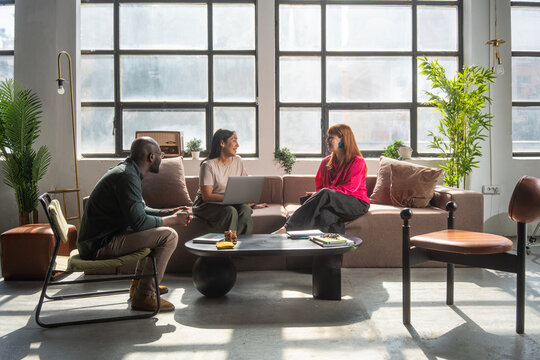 Casual Business Meeting In Modern Office Lounge With Large Windows