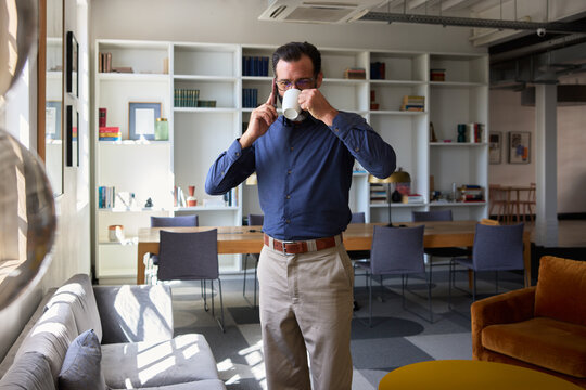 Drinking coffee during a phone call in the office 